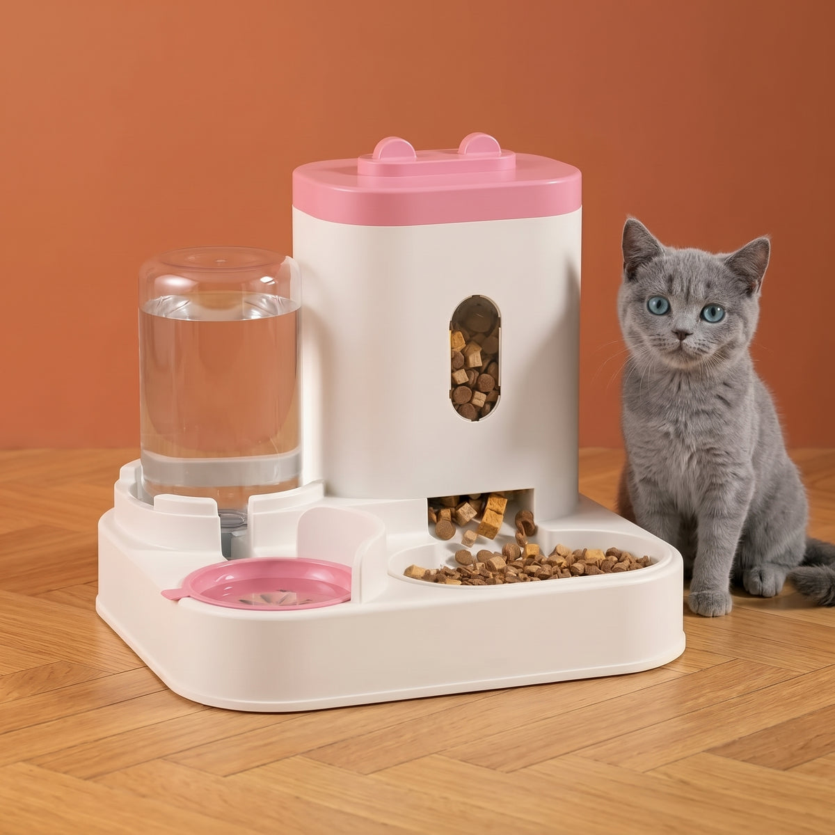 Distributeur 2-en-1 CROQEO rose avec un chaton gris assis à côté